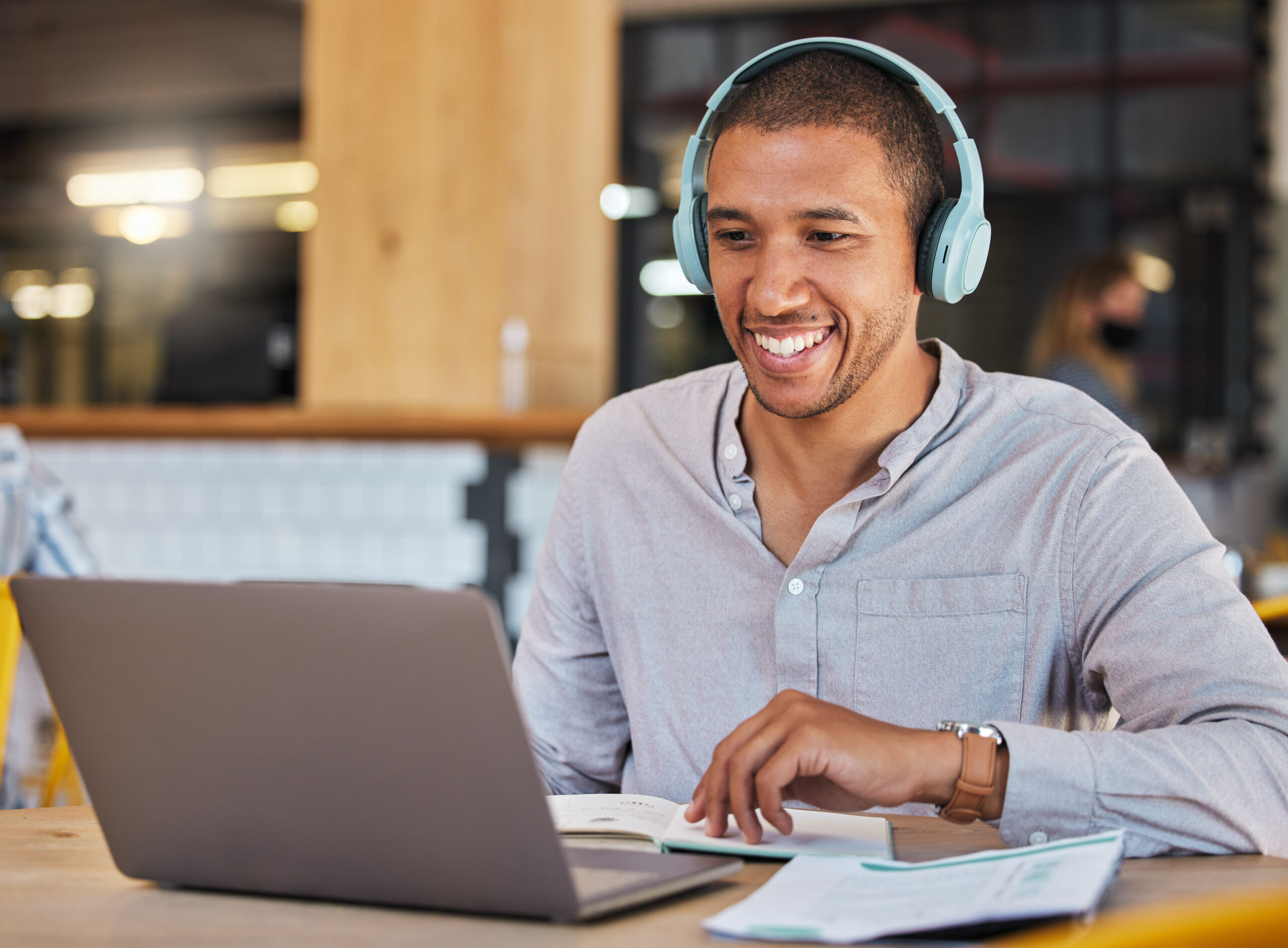 Educator working on laptop with headphones on. 